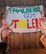 Grupo de jóvenes posando frente a un cartel de 'Paalberg Got Talent' en un parque de vacaciones en Gelderland, Países Bajos.