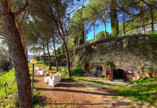 Buitenzithoek bij Casa & Glamping Sorriso in Umbrië, Italië, omgeven door bomen en natuurgroen.