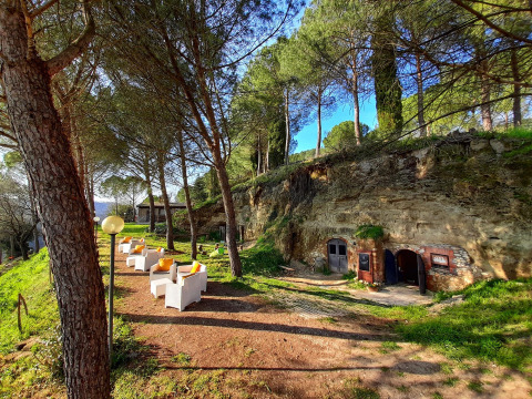 Buitenzithoek bij Casa & Glamping Sorriso in Umbrië, Italië, omgeven door bomen en natuurgroen.