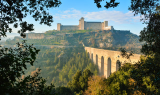 Vista de una fortaleza medieval y antiguo acueducto en el paisaje verde que rodea Baschi, Umbría, Italia.