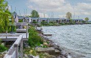 Ferienpark am See mit modernen Hütten, Glamping-Unterkünfte und Holzterrassen, Boote im Hintergrund.