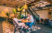 Koppel geniet van een diner in een gezellig restaurant op een vakantiepark met glampingverblijven.