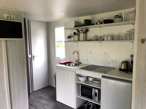 Petite kitchenette dans une tente Coco Deluxe au Vakantiepark Delftse Hout, Pays-Bas, avec équipements modernes.