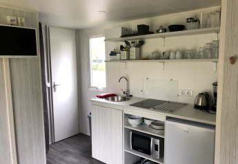 Angolo cottura compatto in una tenda Coco Deluxe al Vakantiepark Delftse Hout, Paesi Bassi, con elettrodomestici.