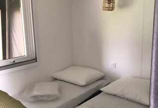 Interior de una tienda safari Coco Deluxe con dos camas individuales en Vakantiepark Delftse Hout, Países Bajos.