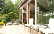 Terraza exterior con tumbonas en Grasdakbungalow, Vakantiepark Delftse Hout, Países Bajos.