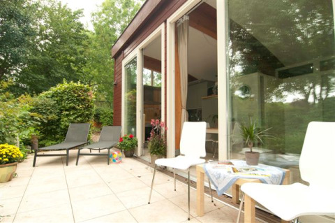 Terrasse extérieure avec transats au Grasdakbungalow, Vakantiepark Delftse Hout, Pays-Bas.