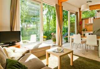 Lyst tiny house interiør med store vinduer, moderne møbler, udsigt til have i Vakantiepark Delftse Hout.