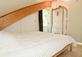 Soveværelse i Grasdakbungalow med skrå loftsbjælke og enkel indretning, Vakantiepark Delftse Hout.