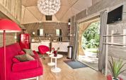 Interno della tiny house Wooden Igloo al Holiday Park Delftse Hout con arredi rossi e cucina moderna.