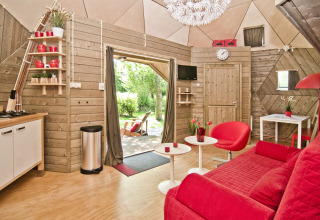 Cozy interior of the Wooden Igloo tiny house at Holiday Park Delftse Hout in the Netherlands.