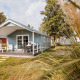 Udendørs billede af en lodge ved Vakantiepark Leukermeer i Holland, omgivet af græs og træer.