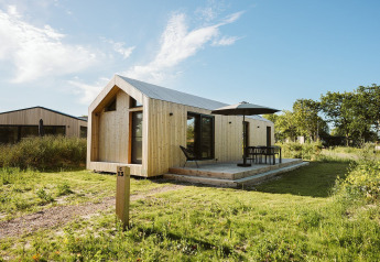 Moderne tiny house van hout met terras en parasol bij Holiday park De Klepperstee in Melle, Nederland.