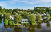 Panoramabillede af Camping Batenstein-ferieparken i Utrecht, Holland, omgivet af træer og vand.