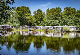 Caravans en tenten aan het water op Camping Batenstein, een vakantiepark in Utrecht, Nederland.