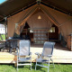 Safari telt ved Camping Oos Heem i Belgien med træterrasse, havestole og spiseområde, klar til brug.