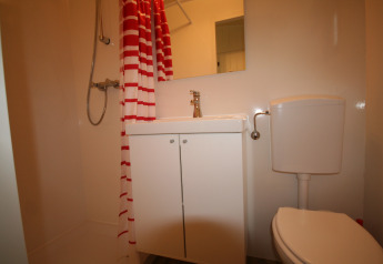Kleines Badezimmer in der Pipowagen-Lodge, Camping De Grienduil, mit Dusche, Waschbecken und WC.