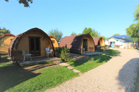 Pequeñas casas arqueadas en Camping De Grienduil, Países Bajos, ideales para una estancia tranquila.