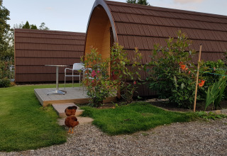 The Megapod VIP tiny house at Camping De Grienduil, Netherlands, with two chickens and garden in front.