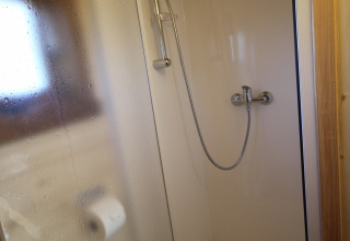 Kleine Duschkabine mit Glas-Schiebetür und Toilettenpapierhalter in The Megapod VIP, Camping De Grienduil.