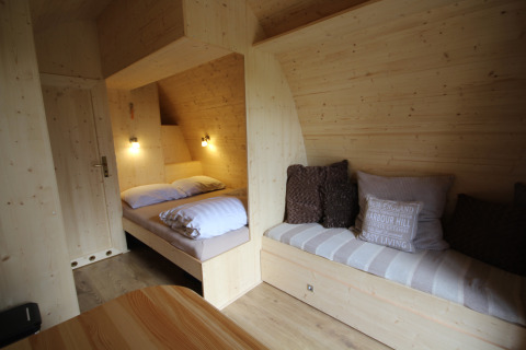 Accogliente interno di una tiny house in legno, The Megapod VIP, al Camping De Grienduil nei Paesi Bassi.