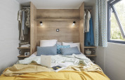 Chambre lumineuse et confortable au design moderne dans une tiny house, fenêtre ouverte, coussins moelleux.