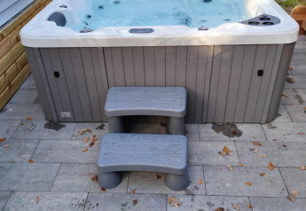Vasca idromassaggio esterna con scalini su patio piastrellato a Luxe Homes nel Bospark De Brenkberg, Paesi Bassi.