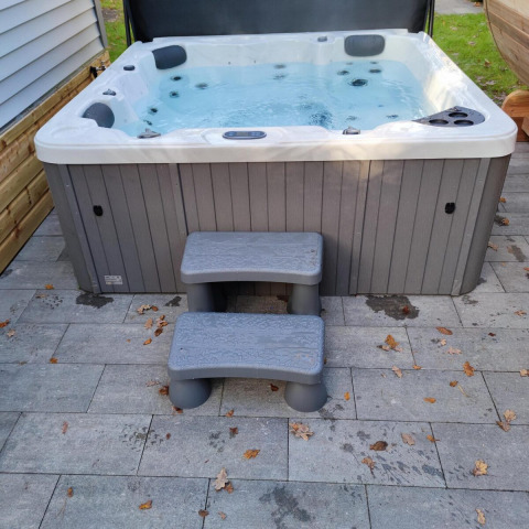 Udendørs spabad med trapper på flisebelagt terrasse ved Luxe Homes på Bospark De Brenkberg, Holland.