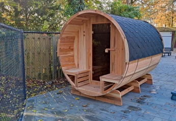 Buitensauna in houten vat bij Luxe Homes, Bospark De Brenkberg, Nederland, omringd door natuur.