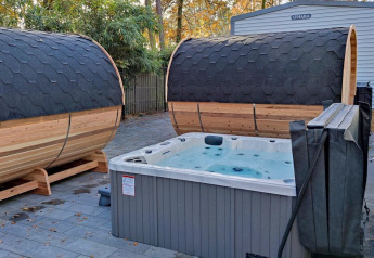 Buitenspa met twee tonvormige sauna’s en een bubbelbad bij Luxe Homes, Bospark De Brenkberg, Nederland.