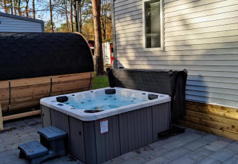 Outdoor hot tub and sauna next to an O'HARA lodge at Bospark De Brenkberg in the Netherlands.