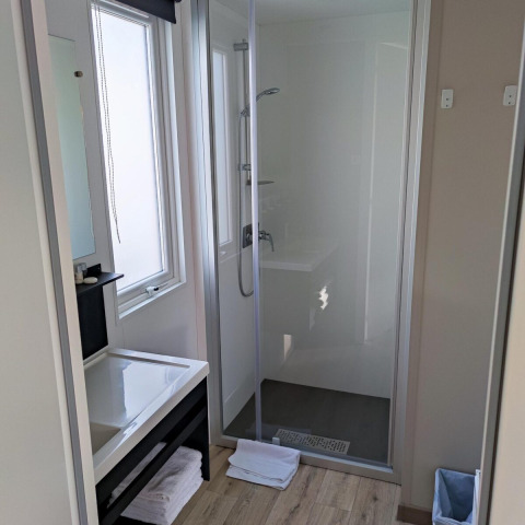 Baño moderno con cabina de ducha, lavabo, espejo y toallas en Luxe Homes, Bospark De Brenkberg, Países Bajos.