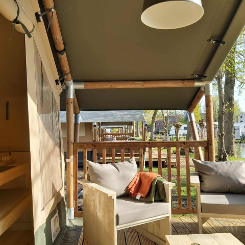 Tiendas safari con muebles de madera y terraza en la Glamping tent de Camping Batenstein, Países Bajos.