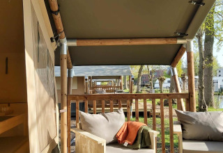 Tiendas safari con muebles de madera y terraza en la Glamping tent de Camping Batenstein, Países Bajos.