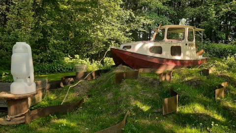 Un pequeño barco está sobre el césped en un claro del bosque en Buytenplaets Suydersee, Flevoland.