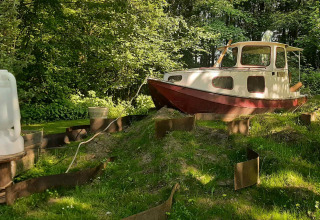 Ein kleines Boot steht auf dem Gras in einer Lichtung bei Buytenplaets Suydersee, Flevoland, Niederlande.
