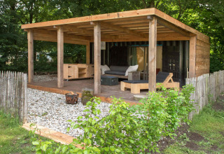 Overdekte buitenlounge met houten terras en meubels bij Buytenplaets Suydersee, Flevoland, Nederland.