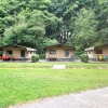 Three safari tents with colorful outdoor seating at Buytenplaets Suydersee, Netherlands, near a forest.