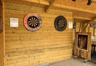 Indendørs dartområde med to dartskiver på trævæg hos Camping De Grienduil, en feriepark i Utrecht, Holland.