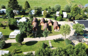 Aerial view of Camping De Grienduil in Utrecht, Netherlands with cabins, caravans, and grassy areas.