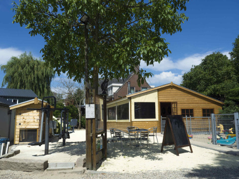 Zona exterior con parque infantil y cabañas de madera en Camping De Grienduil, parque vacacional en Utrecht.