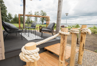 Terraza exterior en Waterlodge tipo 1 en Vakantiepark Bergumermeer, Países Bajos, con vista al lago.