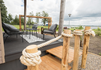Udendørs terrasse ved Waterlodge type 1 på Vakantiepark Bergumermeer, med udsigt over søen.