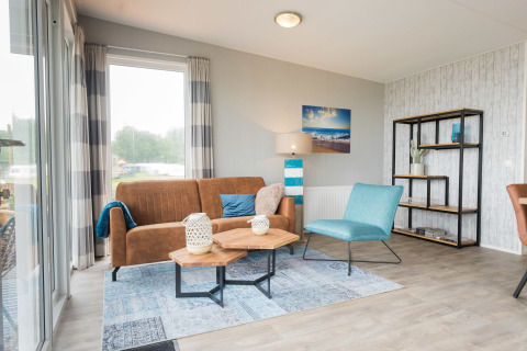 Sala luminosa en Waterlodge tipo 1 de Vakantiepark Bergumermeer, Países Bajos, con decoración acogedora y moderna.