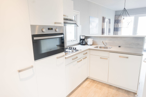 Moderne, lys køkken i Waterlodge type 1 ved Vakantiepark Bergumermeer, Holland, med komfur og vask.