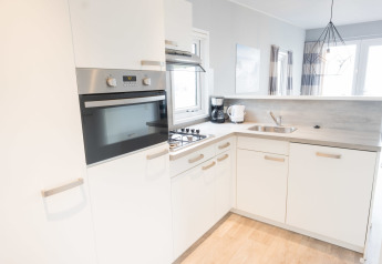 Moderne, lys køkken i Waterlodge type 1 ved Vakantiepark Bergumermeer, Holland, med komfur og vask.
