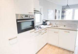 Bright, modern kitchen in Waterlodge type 1 at Vakantiepark Bergumermeer, Netherlands, featuring oven.