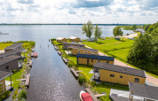 Vista panorámica de la Waterlodge tipo 1 en Vakantiepark Bergumermeer, Países Bajos, junto al agua.
