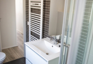 Moderne badeværelse på Waterlodge type 1 i Vakantiepark Bergumermeer med vask, spejl og bruser.