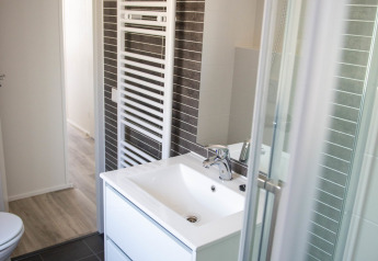 Moderne badeværelse på Waterlodge type 1 i Vakantiepark Bergumermeer med vask, spejl og bruser.